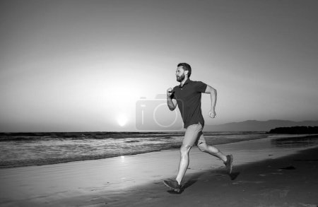 Photo for Portrait of active middle age man jogging running outside by sea - Royalty Free Image