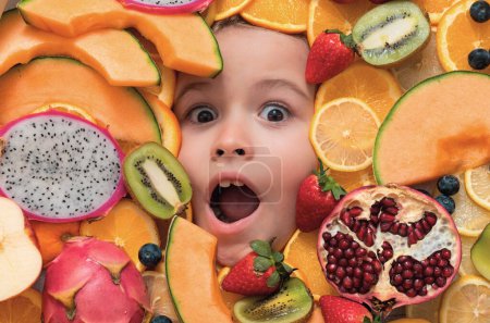 Photo for Vitamins from fruits. Mix of fruits near excited kids face. Assorted mix of summer fresh fruits. Healthy nutrition for kids - Royalty Free Image