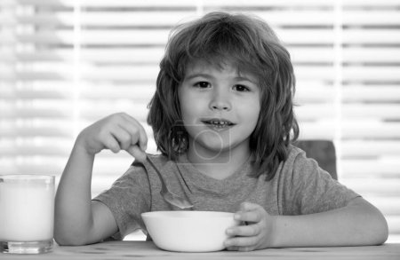 Caucasian toddler child boy eating healthy soup in the kitchen