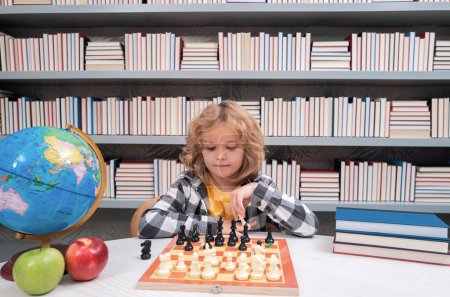 Photo for Child play chess. Clever child thinking about chess. Portrait of clever kid with chessboard. Boy play chess - Royalty Free Image