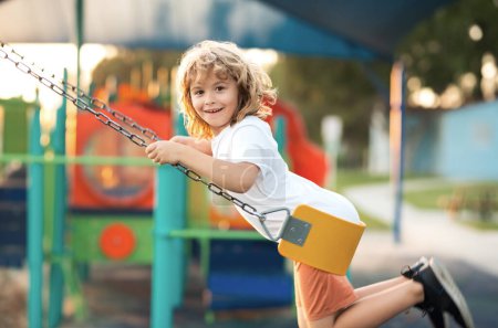 Photo for Kid on swing. Little child having fun on a swing outdoor. Summer playground. Kid swinging high - Royalty Free Image