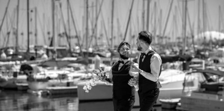 Gay marriage. Gay couple wedding. Two gay men after wedding on a beach near yacht club