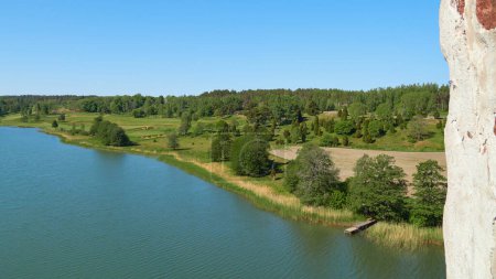 Blick auf die Umgebung vom Schloss Kastelholm auf den Landinseln: Felder, Wald, kleiner Steg, Sommertag.