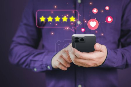 Man hand using a mobile phone with popup five star icon for feedback review satisfaction service and testimonial. Customer service experience and business satisfaction survey.