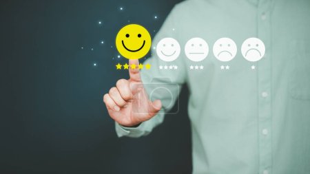 Man berührt den virtuellen Bildschirm auf dem glücklichen Smiley-Gesicht-Symbol, um Zufriedenheit im Dienst zu geben. Bewertung sehr beeindruckend. Kundenservice, Erfahrungsberichte und Zufriedenheitskonzept.