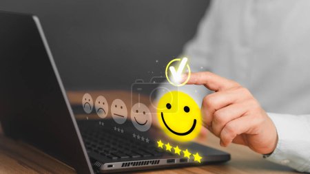 Mano masculina usando una computadora portátil con sonrisa pop-up cara icono de cinco estrellas para comentarios de servicio, satisfacción y testimonios. Experiencia de servicio al cliente y encuestas de satisfacción empresarial.