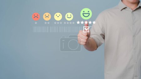 Photo pour Shopper touchant écran virtuel sur l'icône sourire heureux visage pour donner satisfaction dans le service. Note d'opinion très impressionnée. Évaluation témoignage service à la clientèle et concept de rétroaction. - image libre de droit