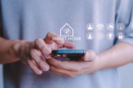 Photo for Adult man control technology AI smart home devices using a mobile phone with launched application. Internet of Things of smart home automation apps concept. - Royalty Free Image