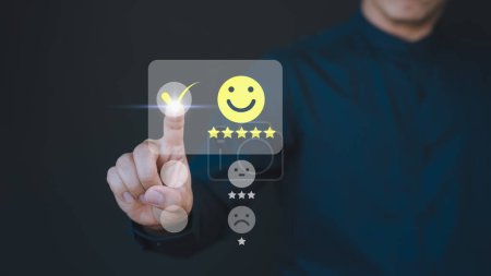 Photo for Customer hand touching the virtual screen on happy smile face icon to give satisfaction in service. Concept of assessment testimonial customer service and feedback, Opinion rating very impressed. - Royalty Free Image