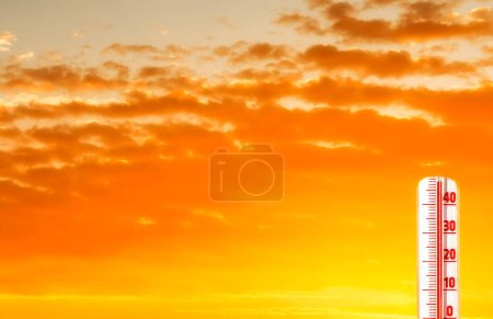 Photo for Thermometer with scale of extreme air temperature and orange clouds due to global warming. Conceptual image symbolizing a drastic climate changes on our planet - Royalty Free Image