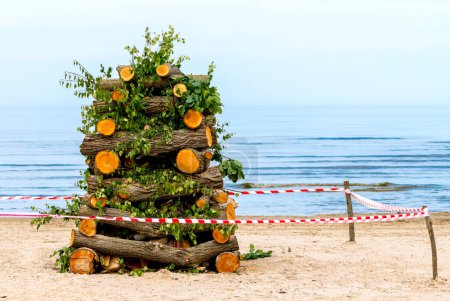 Foto de Playa de arena del Mar Báltico. Cubierta de madera y leña preparadas para un gran fuego para la noche que se utilizará como símbolo de la fiesta tradicional letona del verano - Imagen libre de derechos