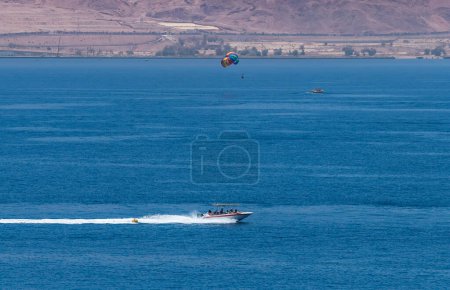 Photo for Excursion on the motorboat at the Red Sea, observing coral reefs, kite and parashot surfing, tourist hotels, sandy beaches and mountains of Israel and Jordan. Panoramic view for Web banner - Royalty Free Image