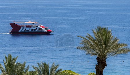 Photo for Excursion on the passenger motorboat at the Red Sea, observing coral reefs and tropical marine fish, tourist resort hotels, sandy beaches and mountains of Israel and Jordan. Colorful view for Web banner - Royalty Free Image