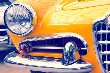 Photo for The hood, bumper, headlight and radiator of a stylish retro yellow car - Royalty Free Image