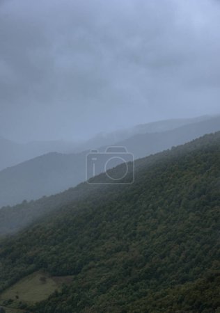 Natürliche Aufnahme von Schichten dunklen Himmels, Bergkette und grünen Wäldern in Kantabrien, picos da europa, leon, asturien, spanien