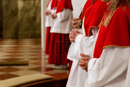 austrian altar servers, acolytes praying in an Austrian church, wearing red and white clothing
