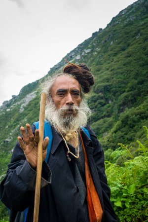 Téléchargez les photos : 14 juillet 2022, Himachal Pradesh Inde. Portrait d'un Sadhu indien avec redoutable serrure homme chignon donnant bénédiction avec les mains pendant Shrikhand Mahadev Kailash Yatra. - en image libre de droit