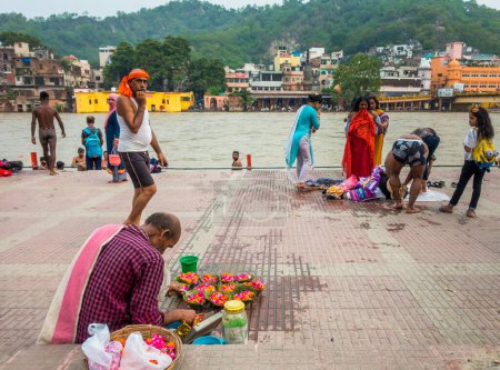 Foto de 8 de julio de 2022 Haridwar India. Un hombre vendiendo flores de colores a orillas del río Ganges para los rituales hindúes. - Imagen libre de derechos