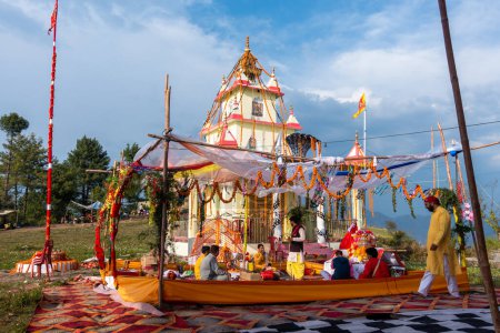 Foto de 28 de junio de 2023 Uttarakhand, India. Un templo hindú decorado dedicado a Naag Devta (Dios Serpiente) durante una ceremonia religiosa con personas que realizan Hawan (una práctica religiosa hindú india)). - Imagen libre de derechos