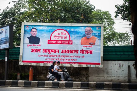Téléchargez les photos : 28 juin 2023.Uttarakhand Inde Panneau d'affichage en hindi sur les bords des routes de l'Uttarakhand, mettant en avant Atal Ayushman Uttarakhand Yojana, en présence du Premier ministre Dhami et du Premier ministre Narendra Modi. - en image libre de droit