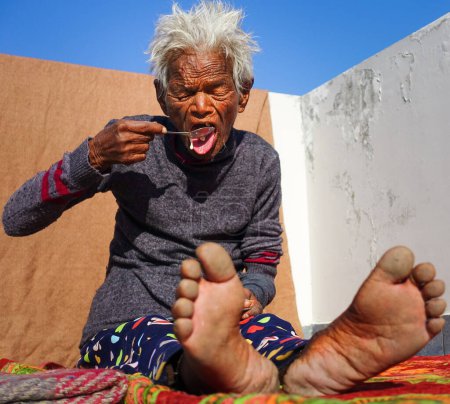 Photo for Oct.14th 2022 Uttarakhand, India. Candid moment: Indian elderly woman being fed with a spoon. Heartwarming and compassionate care. - Royalty Free Image