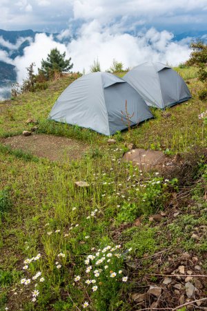 Téléchargez les photos : Les tentes à dôme sont situées au milieu des prairies de l'Himalaya, avec des tentes dressées et une vue panoramique sur le sol. Uttarakhand, Inde. - en image libre de droit
