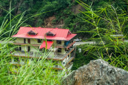 Téléchargez les photos : Immeuble de plusieurs étages à flanc de montagne dans l'Himachal Pradesh, offrant hébergement chez l'habitant et maison de vacances. - en image libre de droit