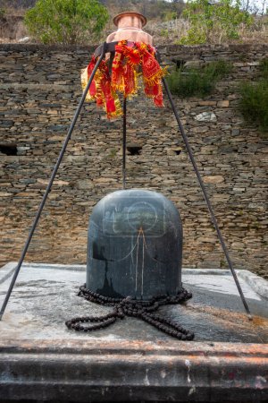 Téléchargez les photos : 18 février 2024, Uttarakhand Inde. Pierre de granit Shivalinga au Temple Lakhamandal Shiva. Il brille comme un miroir et reflète la vue environnante. - en image libre de droit