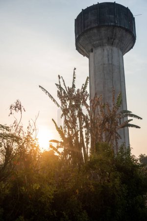 Paysage rural : Vieux réservoir d'eau en béton aérien dans les terres agricoles du nord de l'Inde, baigné par le soleil du matin