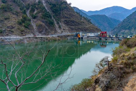 10.April2024, Uttarakhand, Indien. Entdecken Sie die Umweltauswirkungen des Lakhwar-Vyasi-Staudammprojekts am Yamuna-Fluss mit umliegenden Hügeln und einem grünen See.