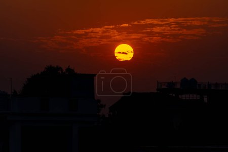 Erleben Sie die Pracht der Natur bei einem lebendigen Sonnenuntergang, der einen orangen Farbton über der Stadt Dehradun, Uttarakhand, Indien, wirft. Eine hypnotisierende Wolkenlandschaft rundet die Szene ab und bietet einen atemberaubenden Sonnenaufgang