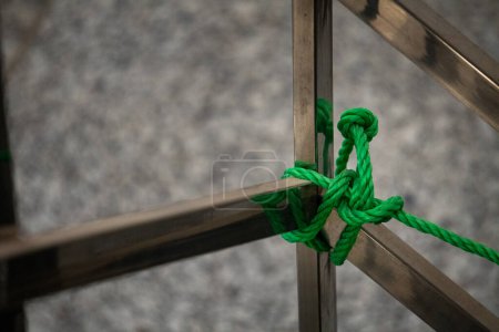 Nylon rope knot on a steel pole. India