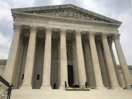 Foto de 24 / 09 / 2020, Washington, DC / USA: El ataúd de la jueza Ruth Bader Ginsburgs en la Corte Suprema. Portadores de pallets con mascarillas están junto al ataúd en las escaleras de la Corte Suprema. - Imagen libre de derechos