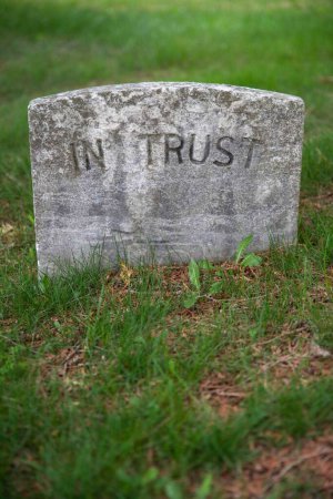 Téléchargez les photos : Image verticale d'une ancienne pierre tombale dans un cimetière vert herbeux. Tombstone lit seulement - - En fiducie. Pas de personnes, espace de copie au premier plan. - en image libre de droit