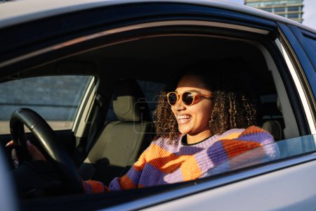 Foto de Retrato de una joven afroamericana sonriente conduciendo un auto. Foto de alta calidad - Imagen libre de derechos