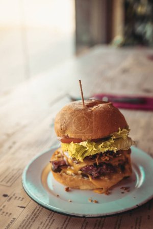 Foto de Alto ángulo de deliciosa hamburguesa con palo servido en plato en la mesa durante el almuerzo en el restaurante - Imagen libre de derechos