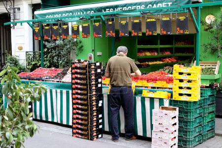 Photo for Paris  France  July 08, 2023 Fresh fruit and vegetable stand attended by Parisian shop owner - Royalty Free Image