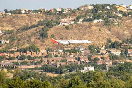Foto de Aerolínea regional Iberia mitsubishi CRJ-1000 CRJX operada por Air Nostrum con matrícula EC-MSL y el tren de aterrizaje bajado para aterrizar en Barajas. - Imagen libre de derechos