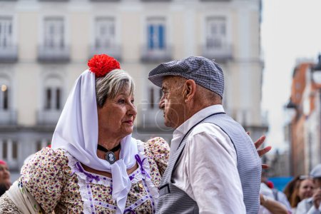 Foto de Madrid, España. 15 de mayo de 2023. Parejas vestidas de chulapos con trajes típicos de Madrid, bailando chotis en el km 0 de la Puerta de Sol en el centro de la ciudad. - Imagen libre de derechos