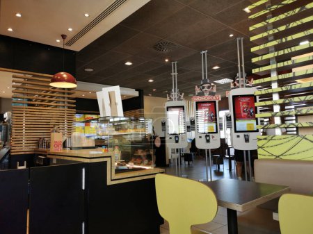 Foto de Futuro Rivas, España. 4 de agosto de 2023. Interior del restaurante McDonald 's en el Parque Comercial Rivas Futura, con vistas a la zona pastelera, cafeterías y máquinas de encargar. - Imagen libre de derechos