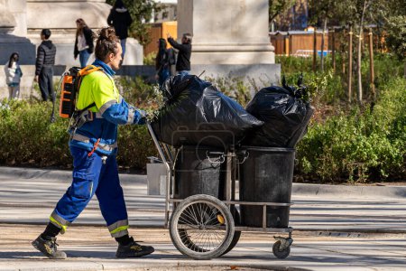 Foto de Madrid, España. 1 de febrero de 2023. Trabajador de limpieza del ayuntamiento de Madrid con un carro de basura trabajando en el centro de la ciudad. - Imagen libre de derechos
