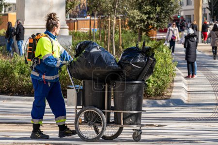 Foto de Madrid, España. 1 de febrero de 2023. Trabajador de limpieza del ayuntamiento de Madrid con un carro de basura trabajando en el centro de la ciudad. - Imagen libre de derechos
