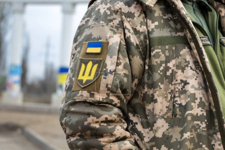 Ukrainischer Soldat in Armee und Flagge, Wappen mit goldenem Dreizack auf uniformiertem Hintergrund. Ukrainische Streitkräfte.