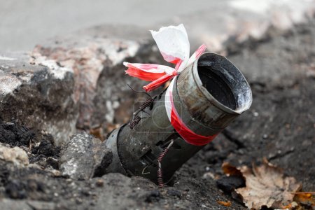 Fragment einer russischen Rakete 122mm Hagel ragt aus dem Asphalt im Zentrum von Cherson, Ukraine. Völkermord an der Ukrainerin. Russland bombardiert die Zivilbevölkerung und die Stadt. Kriegsverbrechen. BM-21
