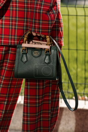 Photo for Milan, Italy - September, 22, 2022: woman wears green leather Gucci Diana mini tote bag, checkered print pattern blazer jacket, matching wide legs pants, street style outfit details - Royalty Free Image