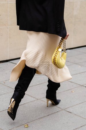 Photo for Paris, France - October, 3, 2022: woman wears wrap front ribbed cotton jersey dress, black suede pointed heels knees boots, high boots, gold chain handbag from Stella McCartney, street style details. - Royalty Free Image