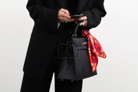 Téléchargez les photos : Paris, France - Octobre, 1 : femme portant le sac à main Kelly en cuir noir de Hermès, détails de tenue de style rue. - en image libre de droit