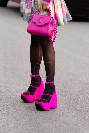 Photo for Milan, Italy - September, 23: woman influencer wearing pink neon Versace La Medusa bag, satin platform heels sandals from Versace. Fashion blogger outfit details, street style. - Royalty Free Image