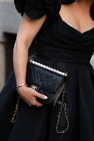 Téléchargez les photos : Milan, Italie - 25 septembre : femme influenceuse portant un sac à bandoulière noir de Chanel. Fashion blogger détails de tenue, style de rue. - en image libre de droit