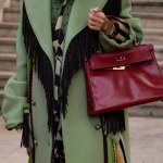 Paris, France - October, 1: woman wearing vintage Kelly 32 bag from Hermes in burgundy calf box leather, street style outfit details.